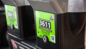 Close-up of a parking meter showing zone number 3611 with a green label indicating payment options via an app with a QR code for Parkmobile.