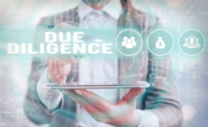 Person in a suit holding a tablet with holographic icons of people, money bag, and magnifying glass. The text "DUE DILIGENCE" is prominently displayed above the icons.