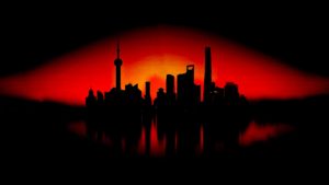 Silhouette of a city skyline with various skyscrapers and towers set against a vivid red and black sunset background, reflecting on a body of water, symbolizing the vigilance and protection akin to cybersecurity measures guarding our digital world.