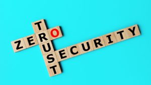 Wooden letter tiles spell out "ZERO TRUST SECURITY" against a blue background, with the "O" in "ZERO" strikingly highlighted in red.