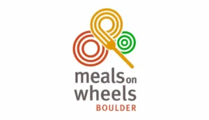 Logo of meals on wheels boulder featuring three interlinked circles in red, orange, and green, with a spoon on the left side, and the organization's name below.