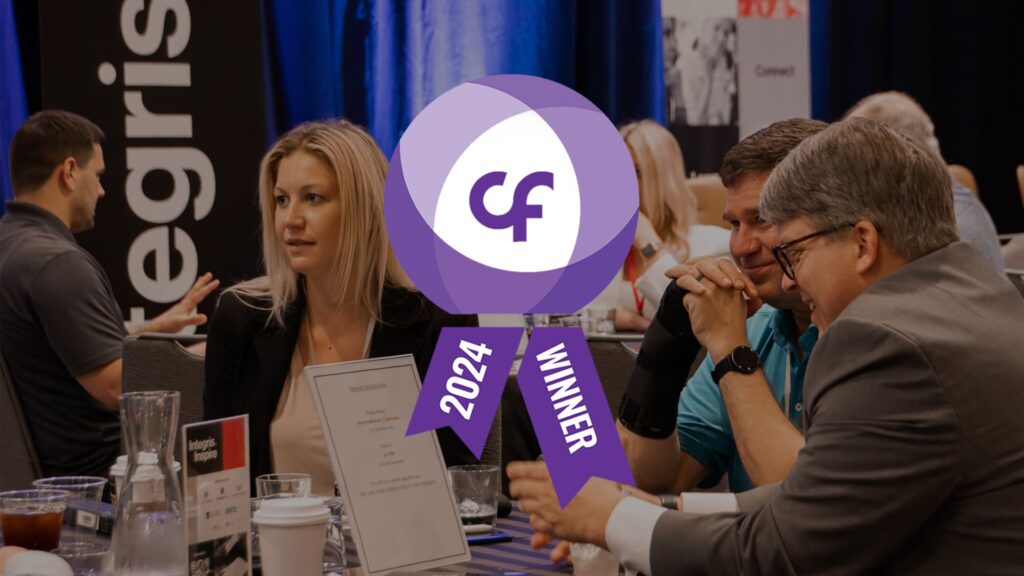 People engaged in conversation at an Integris Inspire event - the Channel Futures MSP 501 2024 Winner award graphic overlaid