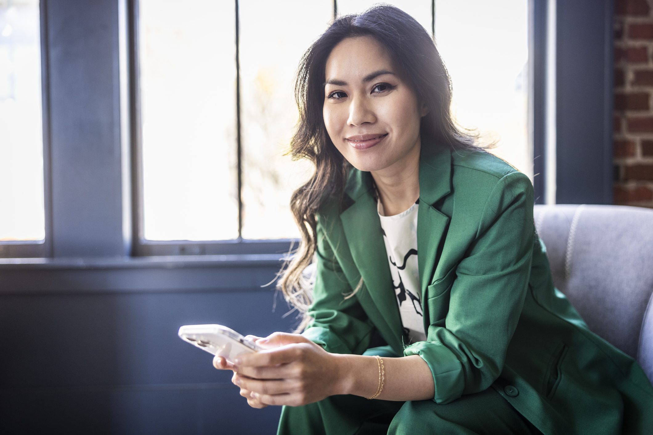 Portrait of of young businesswoman using smartphone in modern office