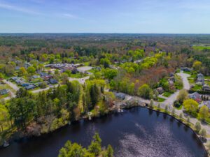 Aerial view of a suburban neighborhood in Owings Mills, MD, surrounded by trees and a small lake under a clear blue sky—an ideal setting for businesses seeking reliable managed IT solutions.