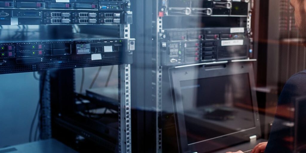 Network engineer troubleshooting in a server room.