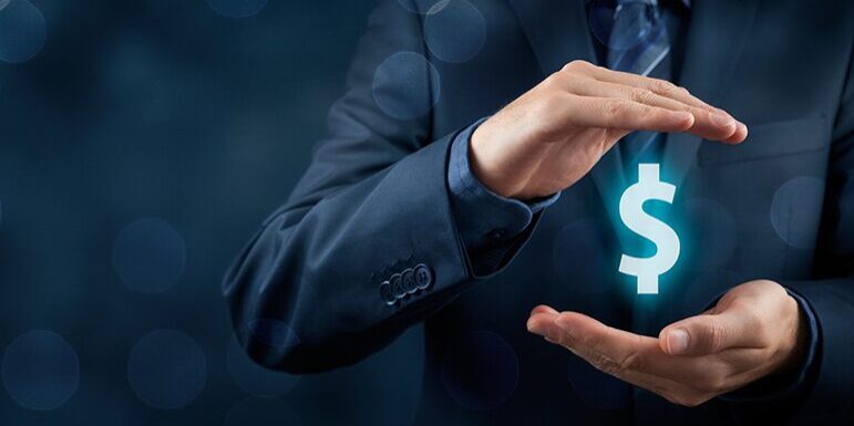 A person in a business suit holds a glowing dollar sign between their hands, symbolizing financial protection or growth.