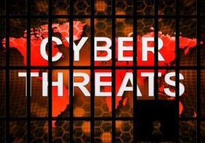 A digital graphic displaying the words "Cybersecurity Threats" over a world map, with hexagonal patterns and a padlock silhouette in the foreground.