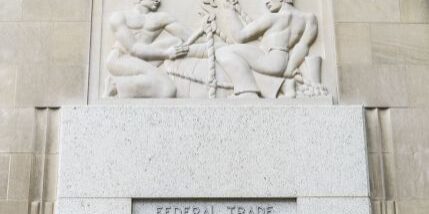 A bas-relief depicting two figures with ropes adorns the entrance of the Federal Trade Commission building, symbolizing the new FTC safeguards.