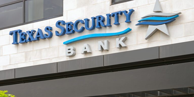 Texas Security Bank sign displayed on a modern building exterior, featuring bold blue lettering and a distinctive stylized star logo.