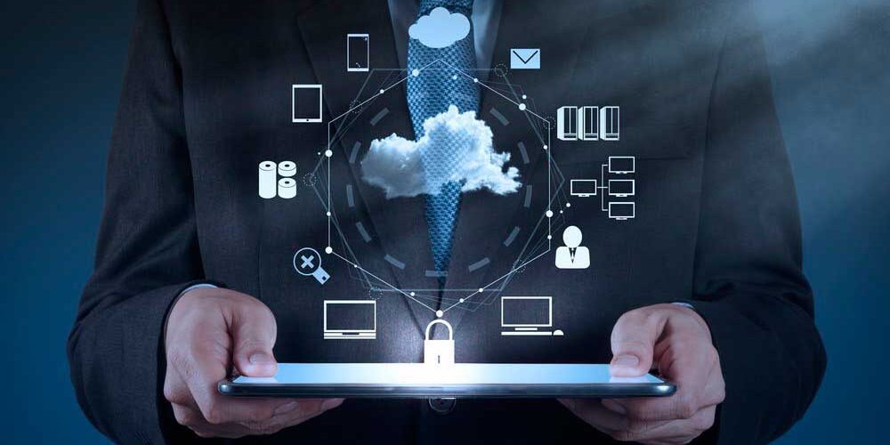 A person in a suit holds a tablet displaying holographic technology icons related to cloud computing and data security.