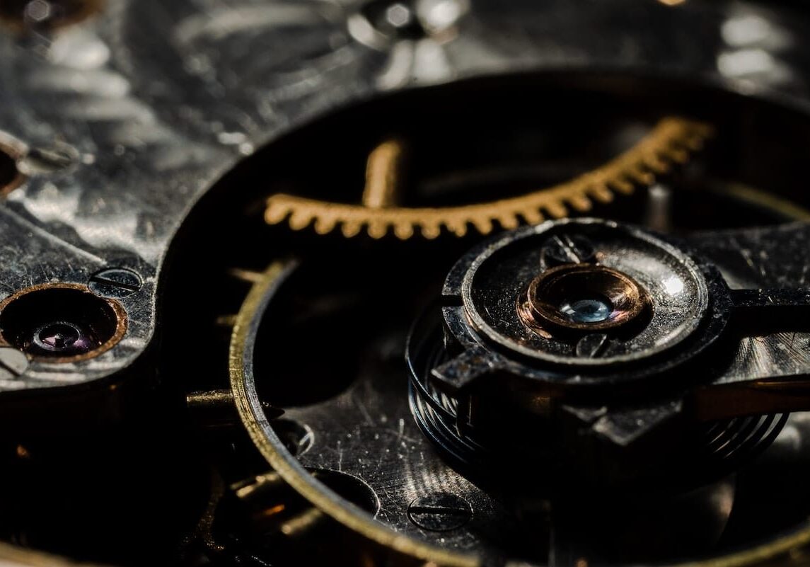 Close-up view of intricate gears and components inside a mechanical watch, resembling the complexity of IT architecture.