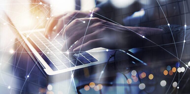 Close-up of hands typing on a laptop keyboard, overlaid with a network of connected lines and dots, symbolizing global digital connections.