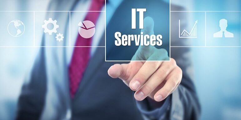 A professional in a suit points at a transparent screen displaying "IT Services" alongside icons of a globe, gear, pie chart, bar graph, and user symbol.
