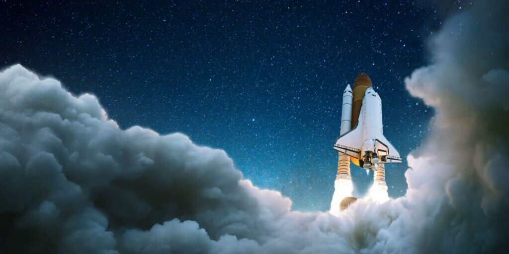 A space shuttle launches into the night sky, surrounded by clouds and illuminated by its engines with a starry background.