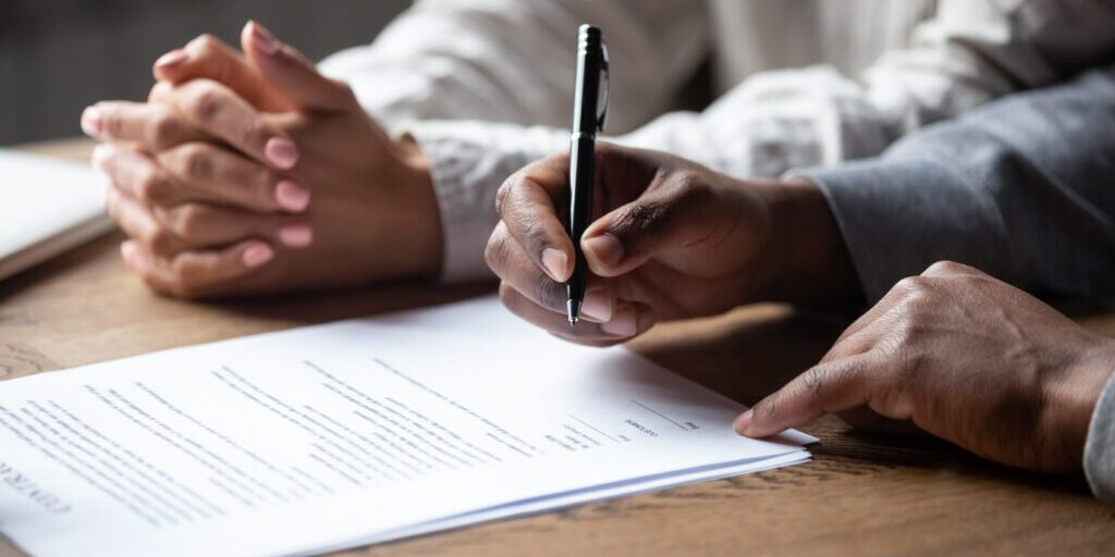 Person preparing to sign a retainer document.