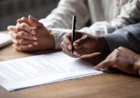 Person preparing to sign a retainer document.