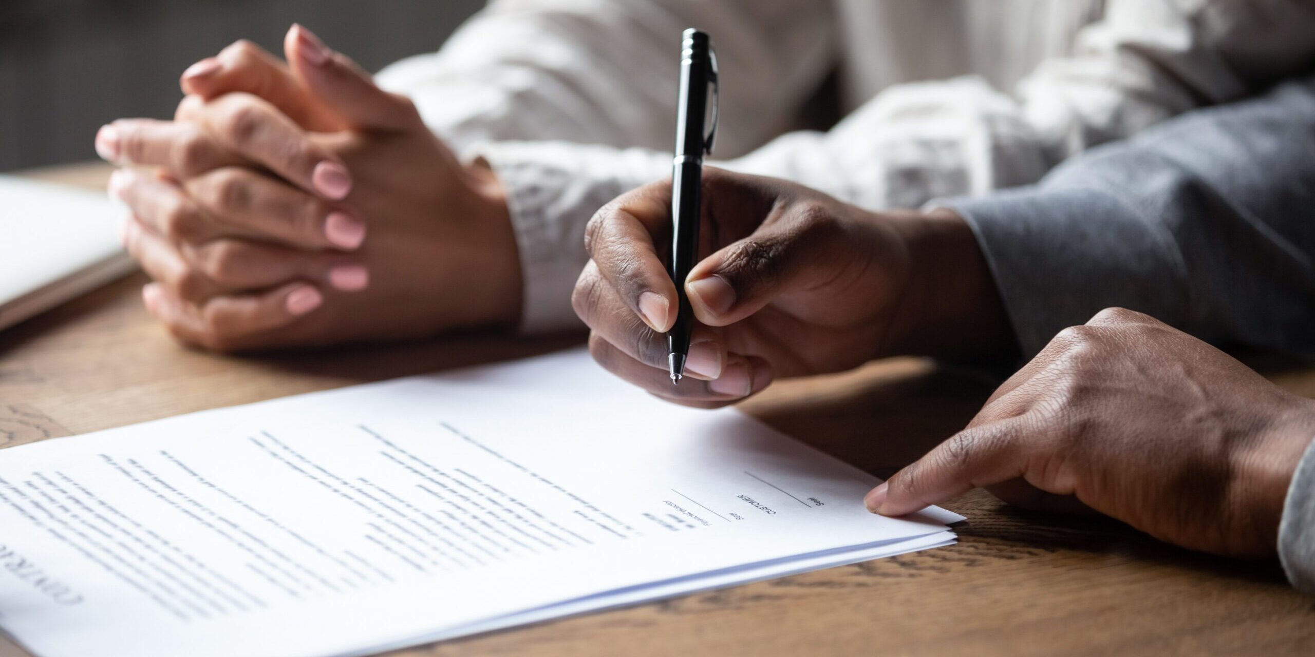 Person preparing to sign a retainer document.