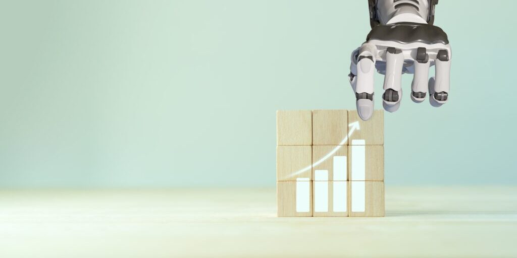 A robotic hand, exemplifying automation, is placing a wooden block on a stack of three others, forming a bar graph. The graph features an upward arrow symbolizing growth or progress. The background is minimalistic in light shades of green and beige.